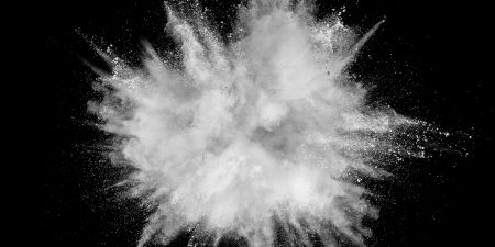 White powder explosion isolated on black background. White dust